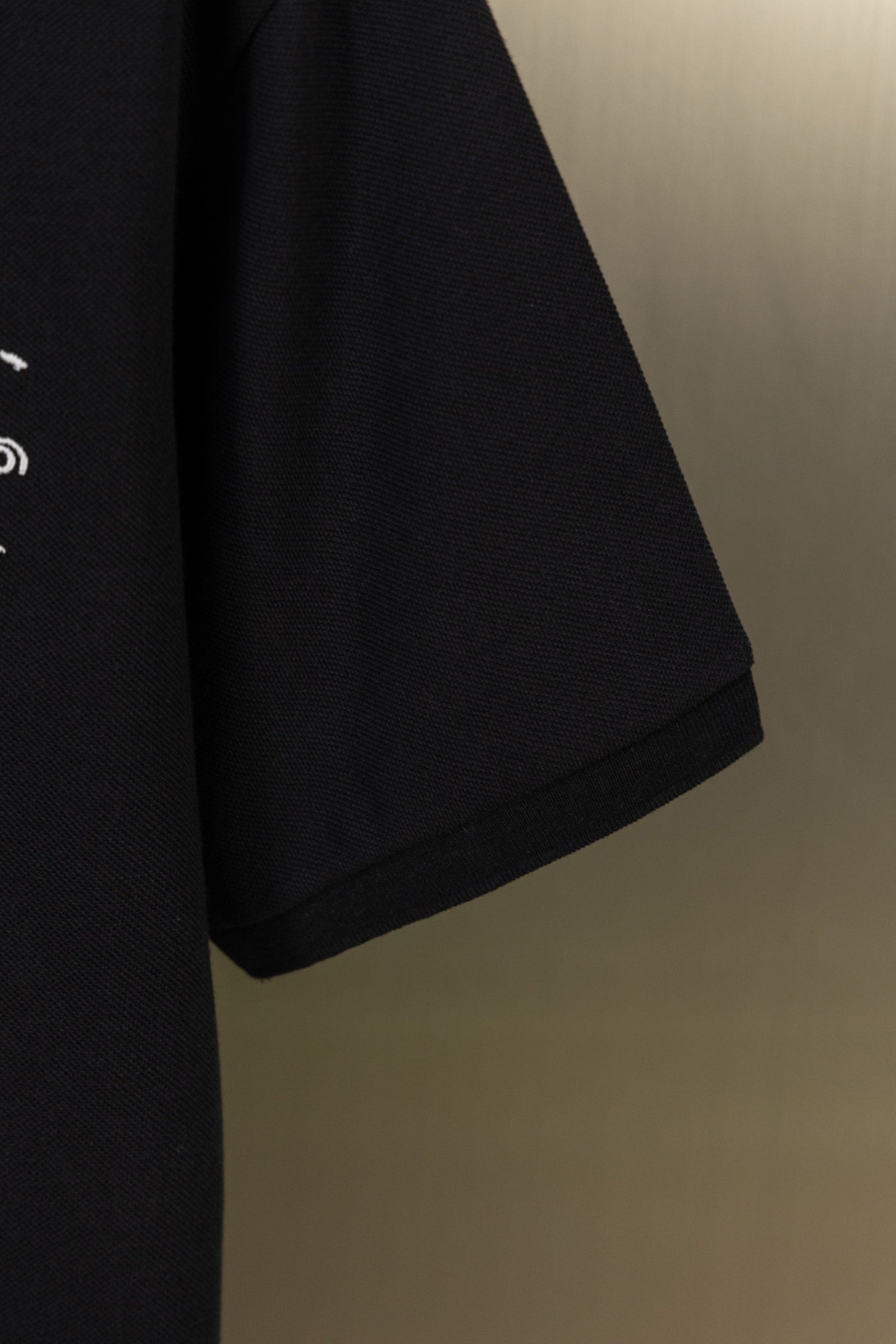 Black polo shirt sleeve and short cuff hem detail