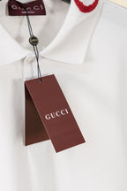 White polo shirt with Gucci-branded neck tag and brown hang tag