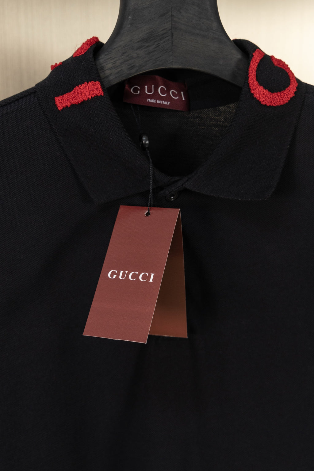 Black Gucci polo shirt with Gucci hang tag, red logo trim at collar