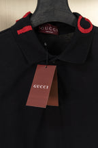 Black Gucci polo shirt with Gucci hang tag, red logo trim at collar