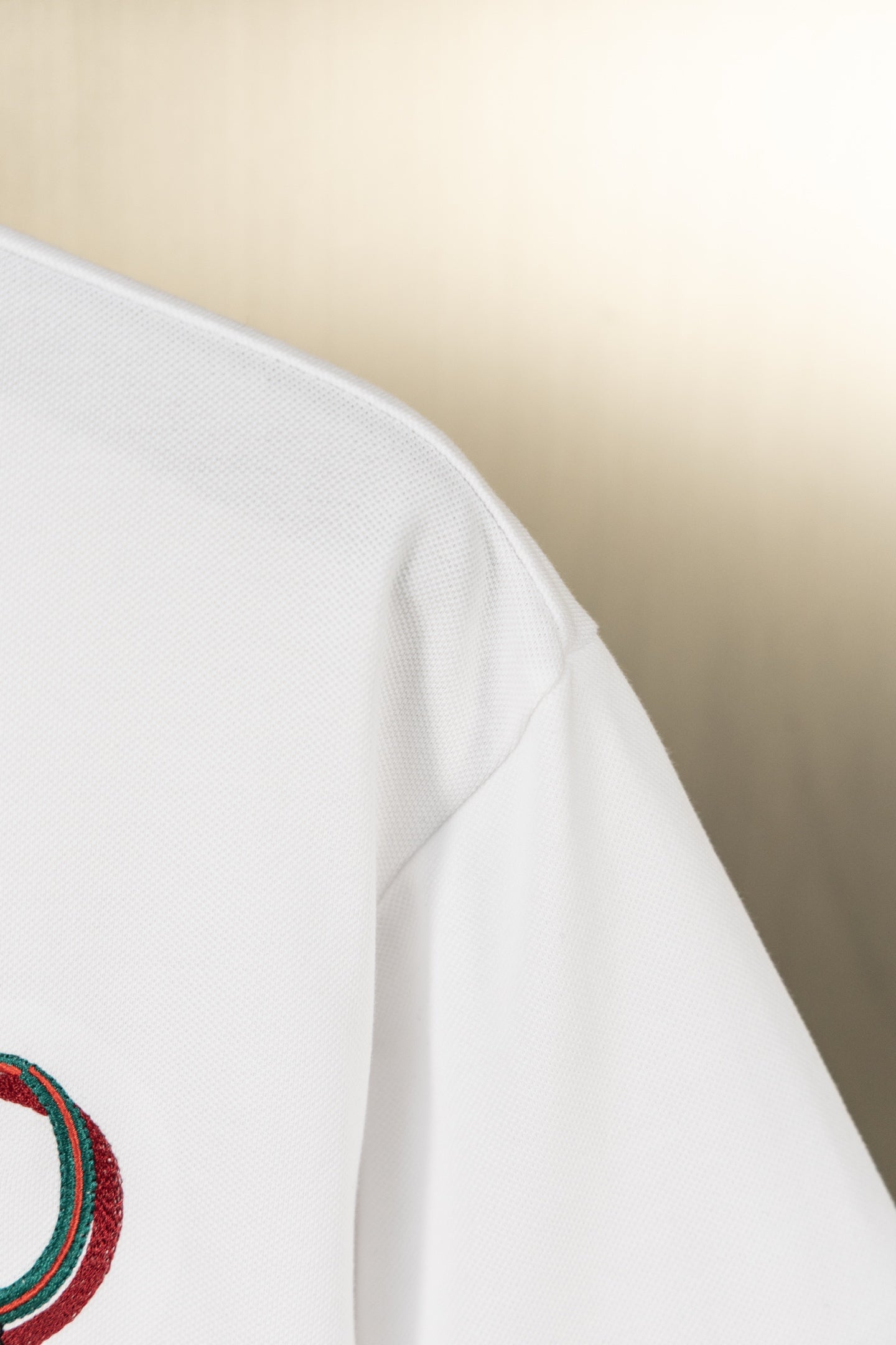 Gucci polo shirt shoulder seam on white fabric