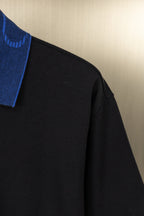 Black polo shirt sleeve and shoulder seam detail