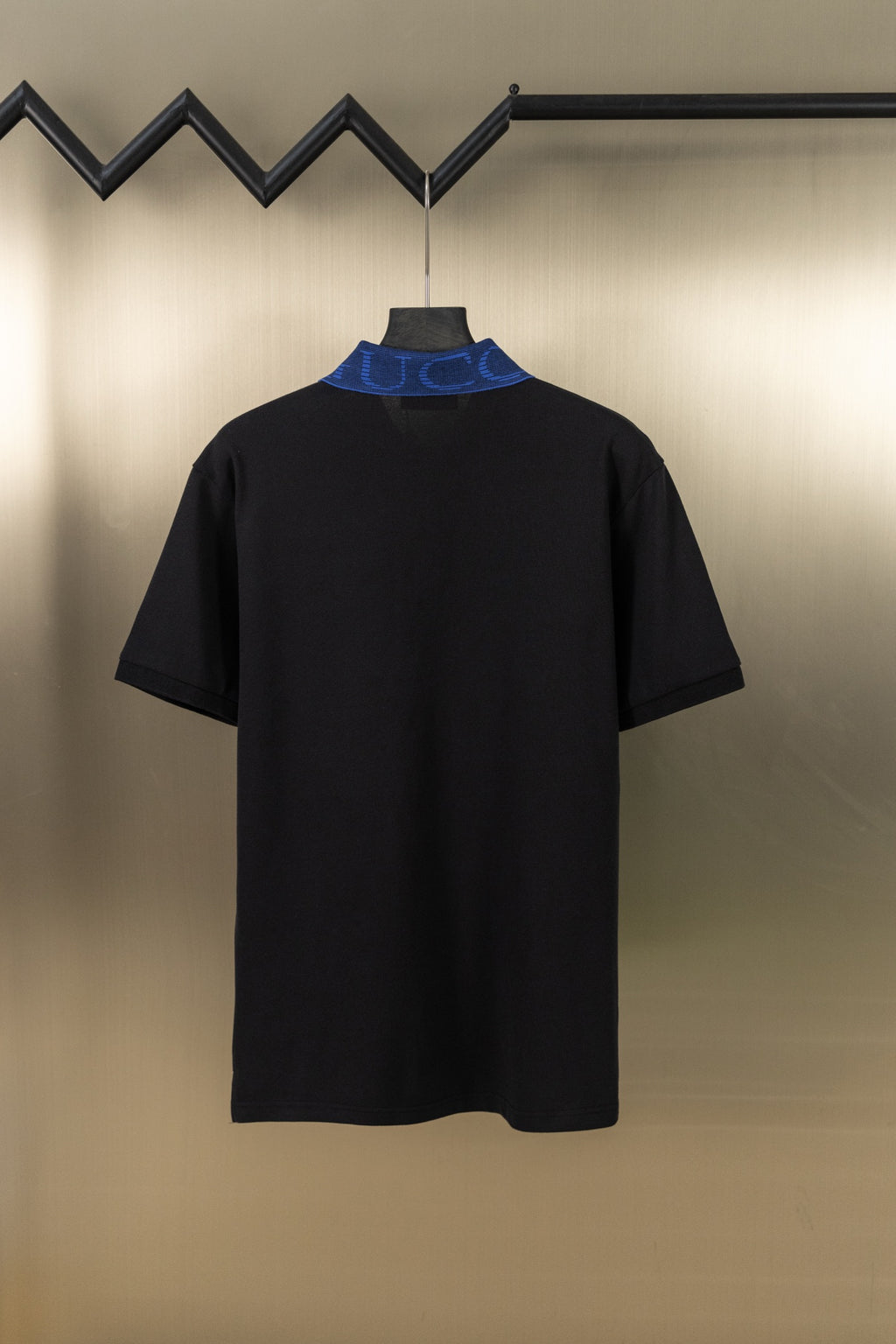 Black polo shirt with blue contrast collar and short sleeves