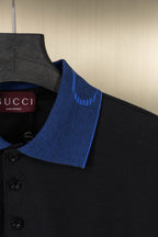 Black polo shirt shoulder with blue collar trim and buttons