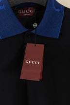 Black polo shirt with blue collar and hanging Gucci price tag