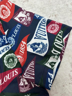 Short-sleeve shirt fabric close-up with multicolor Louis Vuitton crests and logo blocks