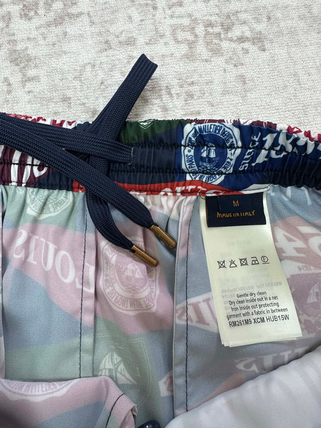 Multicolor shorts with navy drawstring, elastic waistband, and size label
