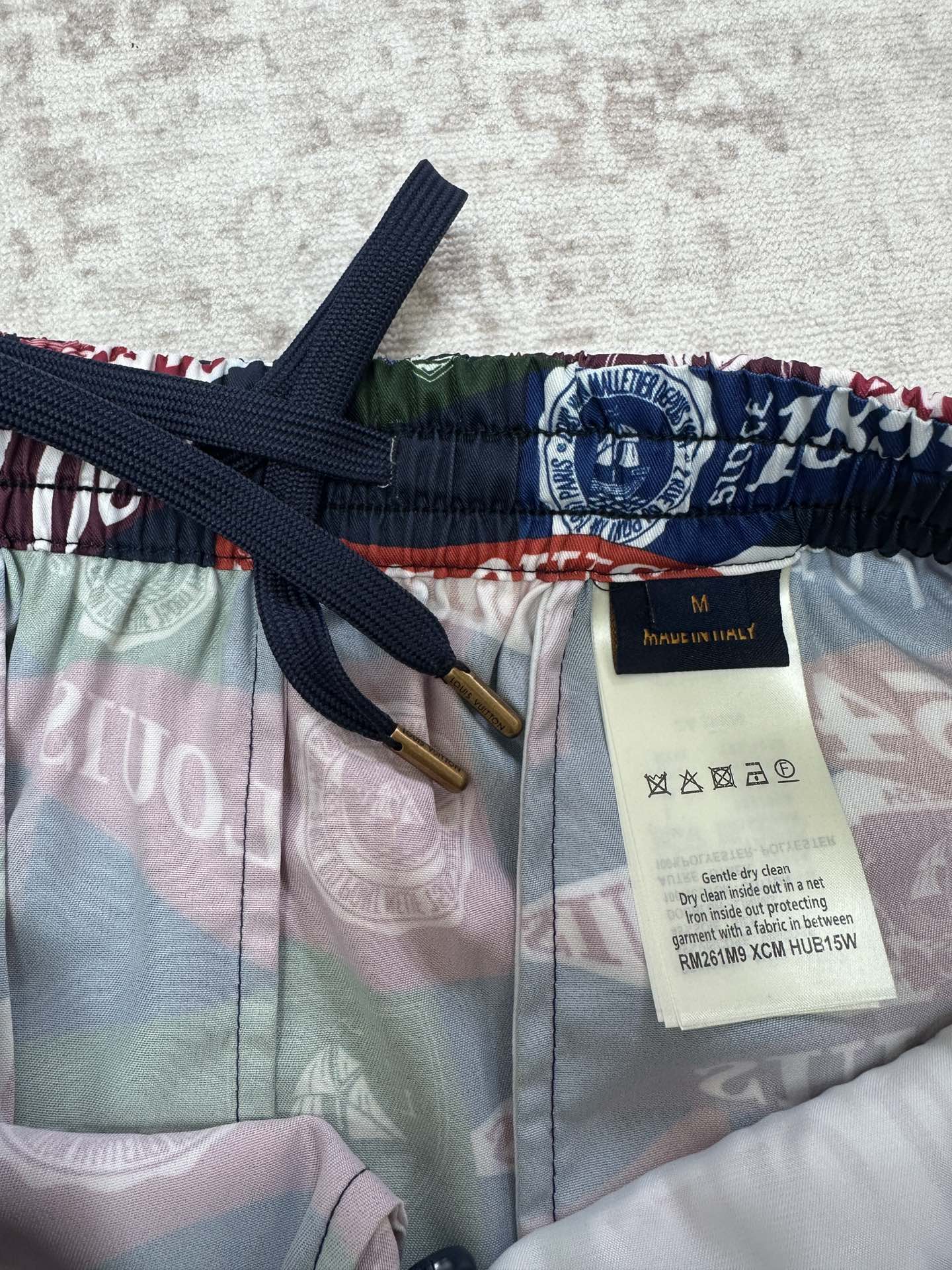 Multicolor shorts with navy drawstring, elastic waistband, and size label