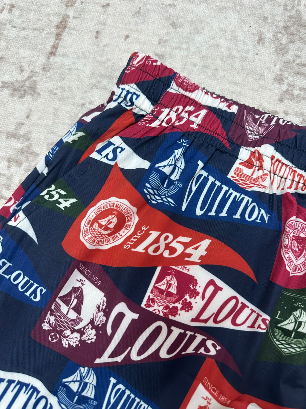 Multicolor shorts with elastic waist, bold stripes and sailing-graphic logo print