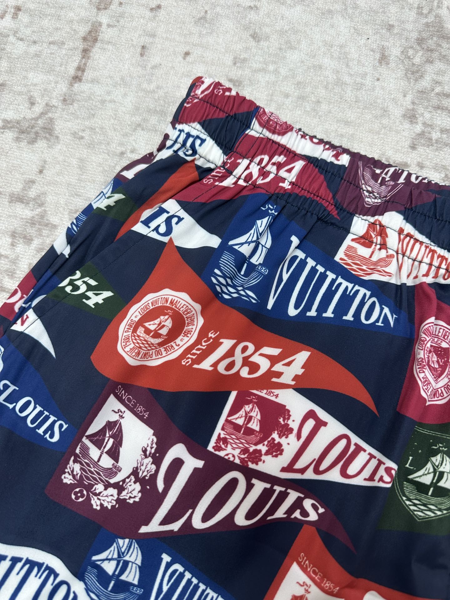 Multicolor shorts with elastic waist, bold stripes and sailing-graphic logo print