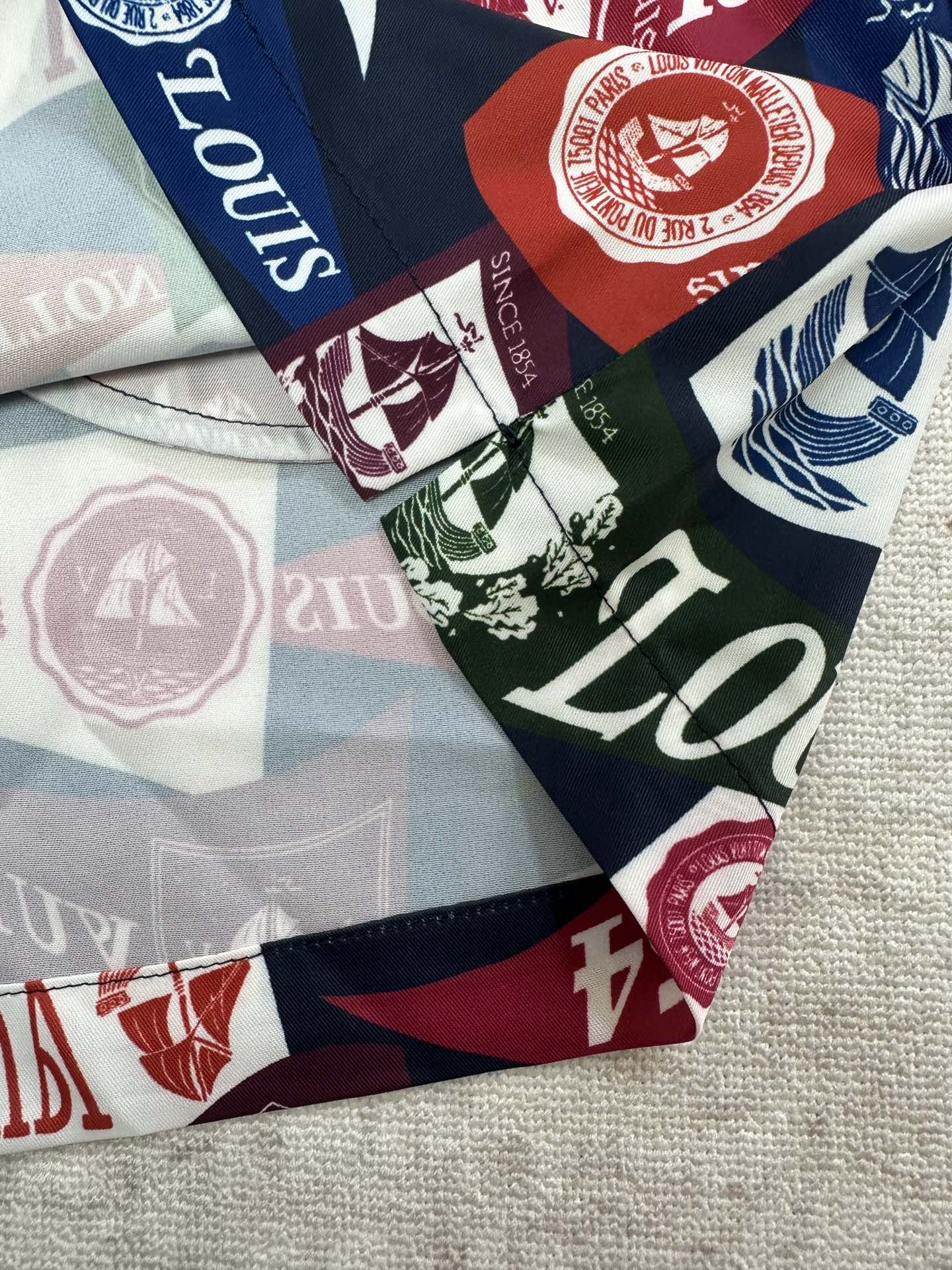Close-up of multicolor shorts fabric with logos, seals, and 1854 emblems