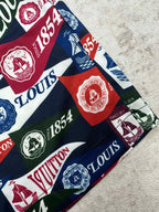 Close-up of multicolor logo shorts fabric with crests and 1854 text