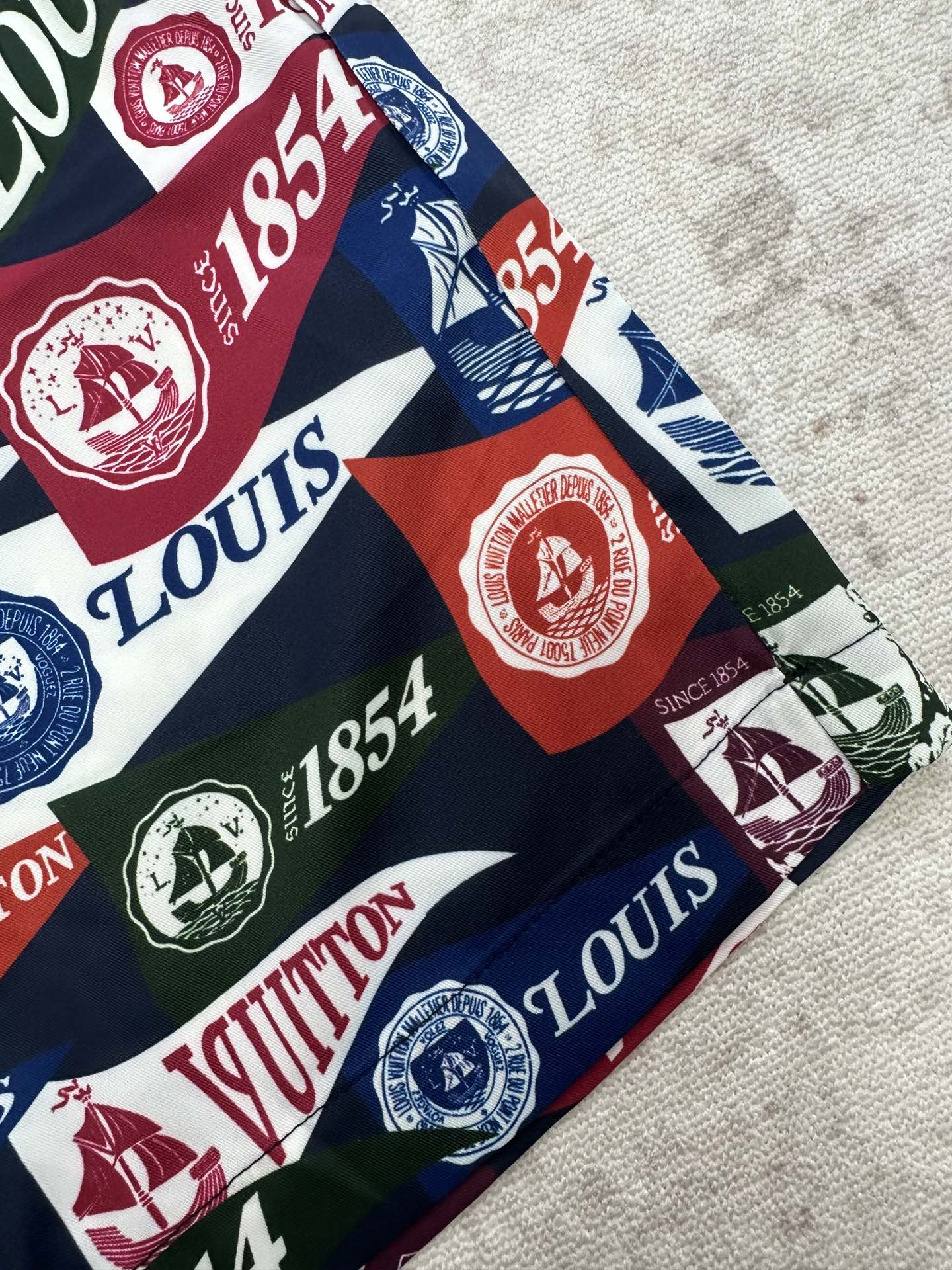Close-up of multicolor logo shorts fabric with crests and 1854 text