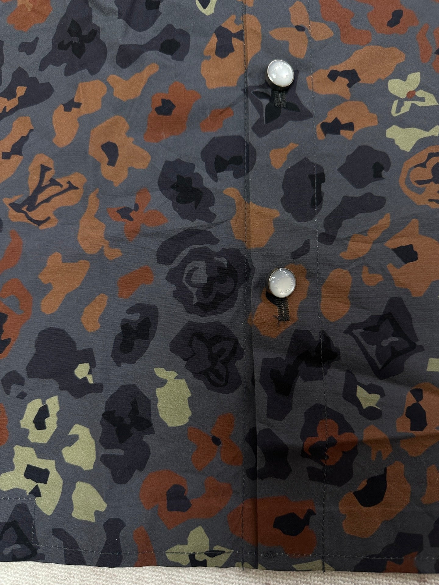 Louis Vuitton short-sleeve shirt fabric close-up with button detail on multicolor print