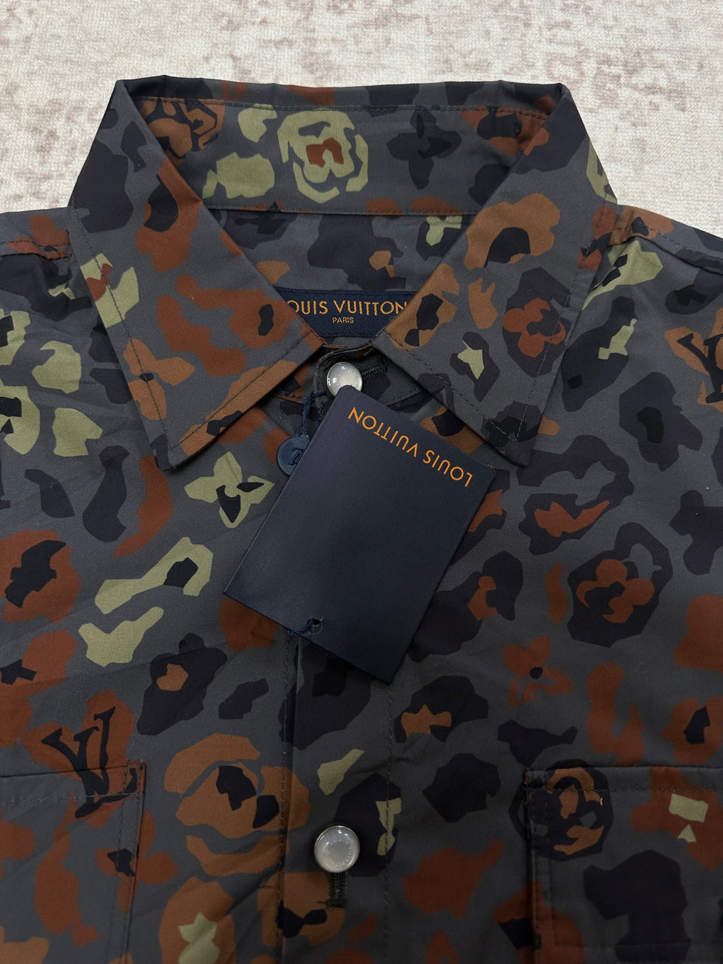 Louis Vuitton short-sleeve shirt fabric close-up with collar and branded hang tag