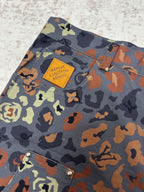 Patterned shorts fabric with Louis Vuitton patch label near the upper pocket