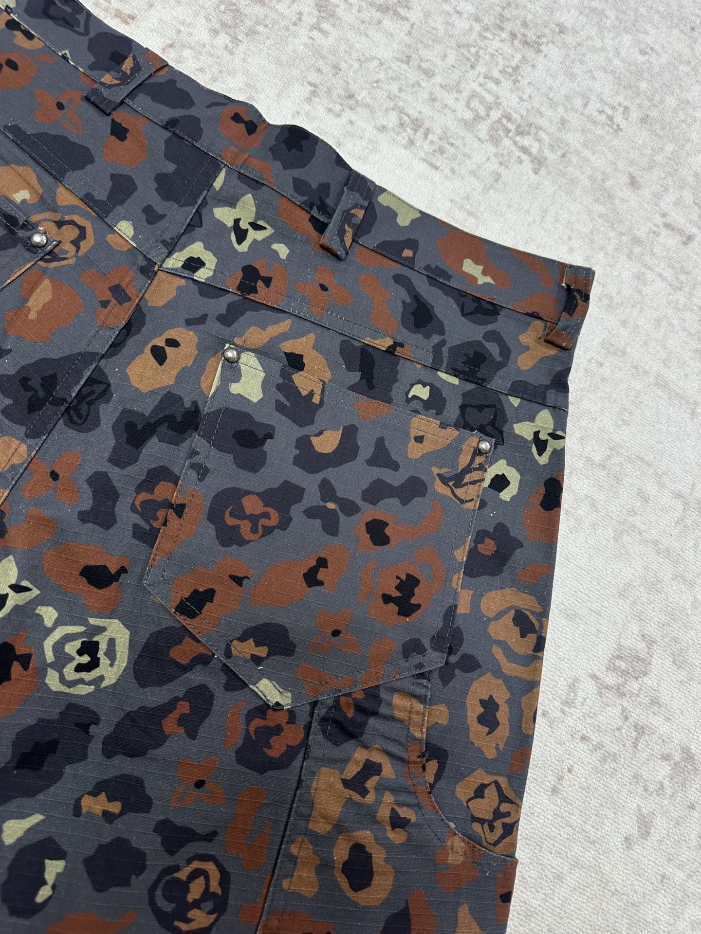 Patterned shorts front corner with belt loops, button details, and pockets
