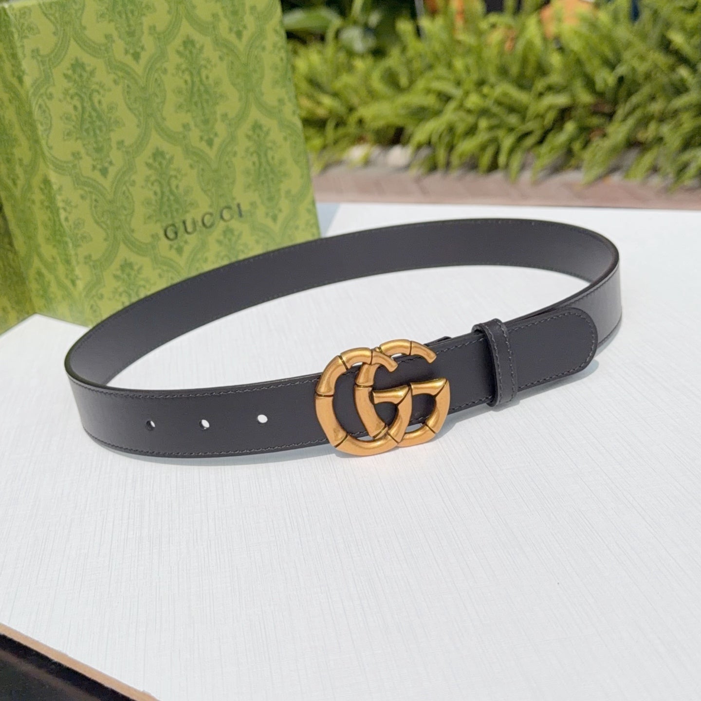 Gucci leather belt in dark black with gold-tone interlocking buckle and punch holes