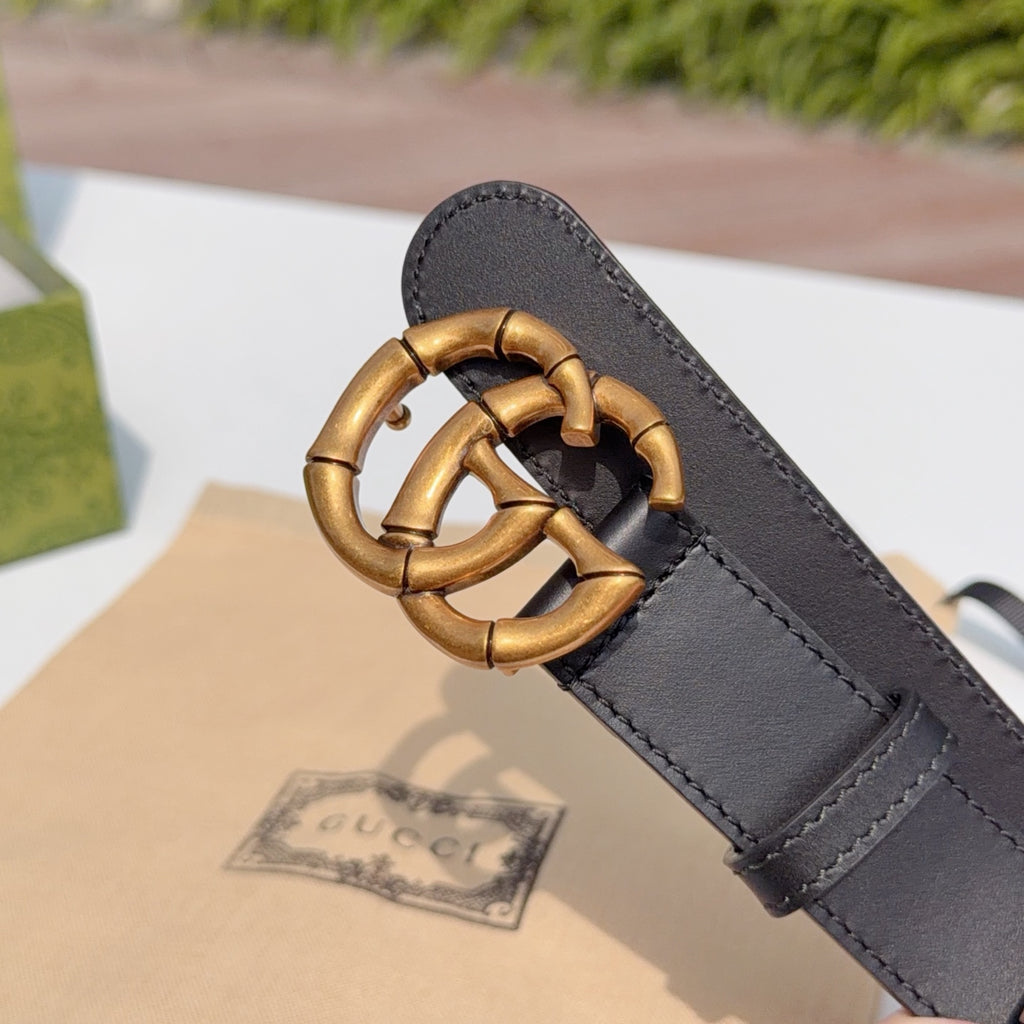 Gucci leather belt buckle close-up on dark black leather strap with gold-tone hardware