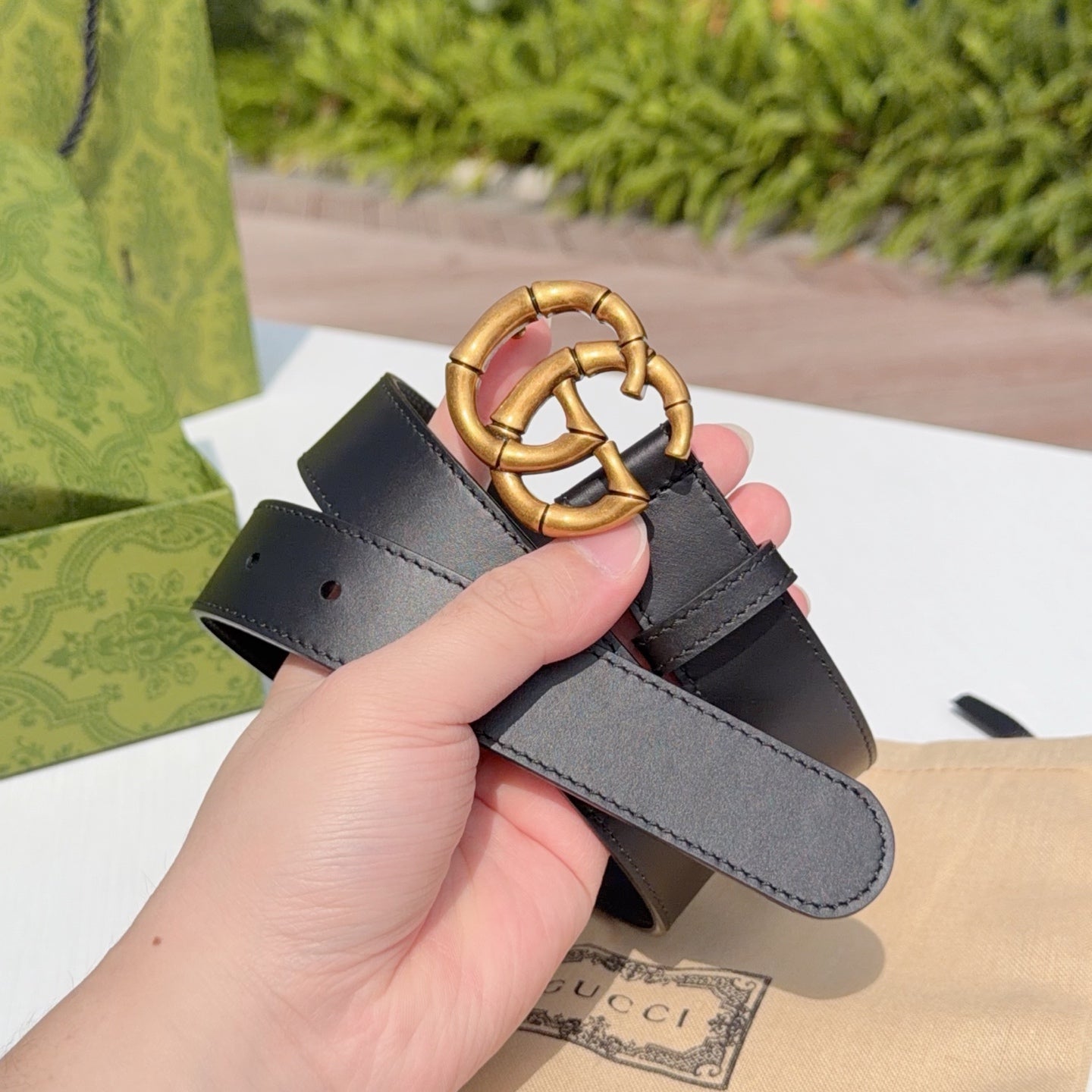 Gucci leather belt in dark black with gold-tone interlocking buckle and adjustable end