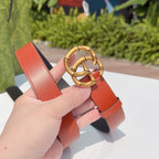 Gucci belt end with red leather strap and gold buckle detail on black backing