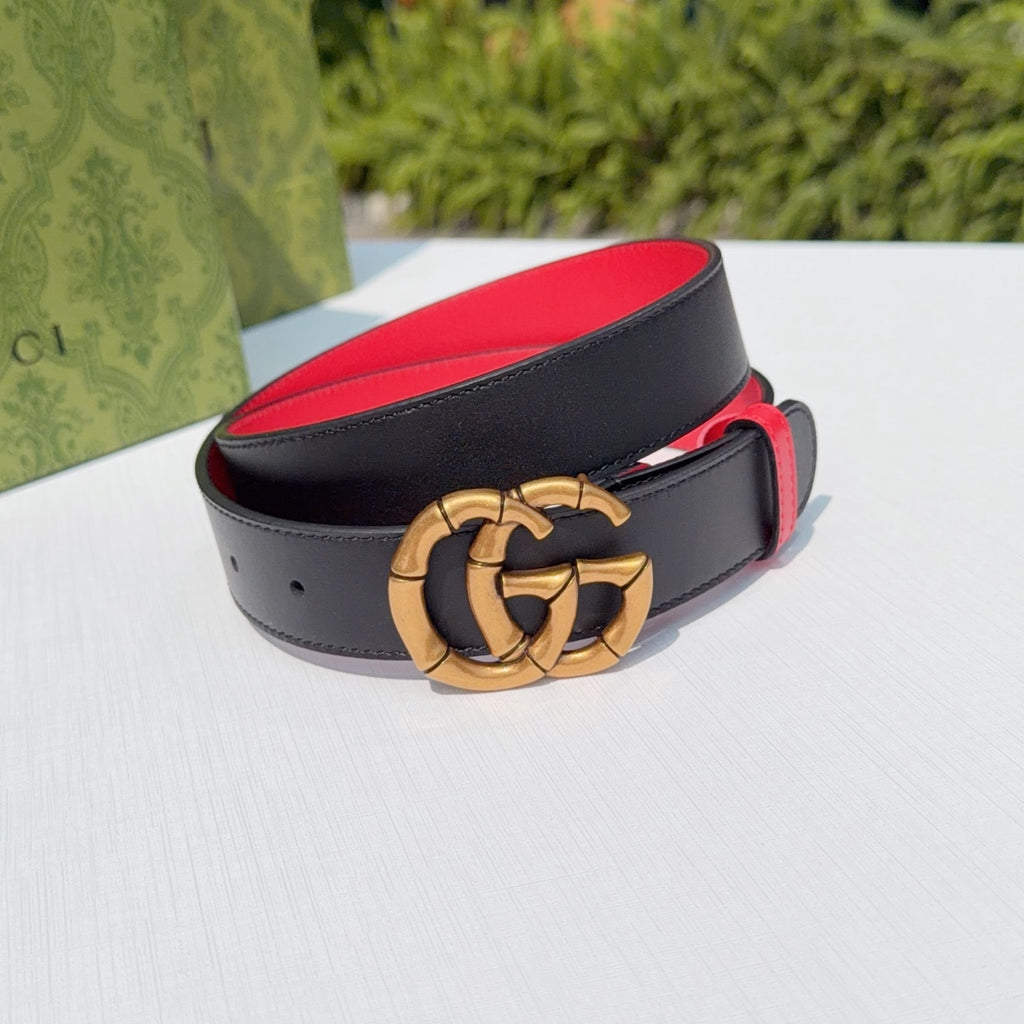 Gucci leather belt with black strap and red accents, featuring gold double-G buckle