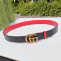 Gucci leather belt with black strap, red lining, and gold double-G buckle