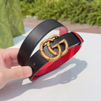 Gucci leather belt buckle close-up: gold double-G on black strap with red edge