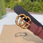 Gucci belt buckle detail on maroon leather strap with dark backing