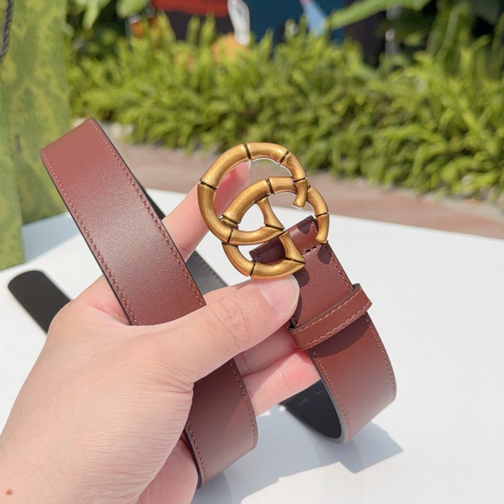Gucci belt end view with gold interlocking buckle and maroon leather strap