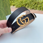 Gucci belt close-up: gold-tone double-G buckle on dark leather strap