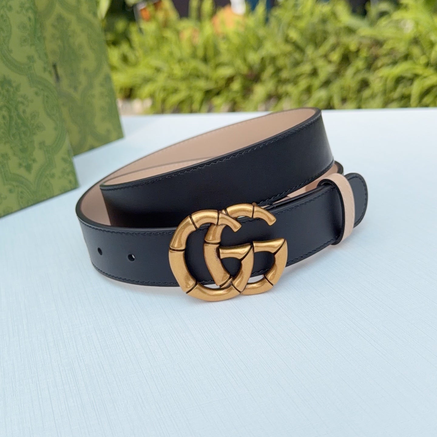 Gucci belt with gold-tone double-G buckle, tan inner strap, dark leather