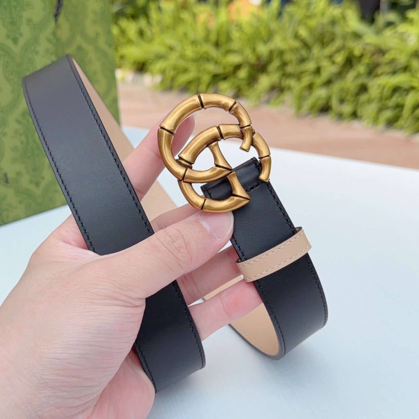 Gucci belt buckle detail with gold-tone double-G, dark leather and tan backing