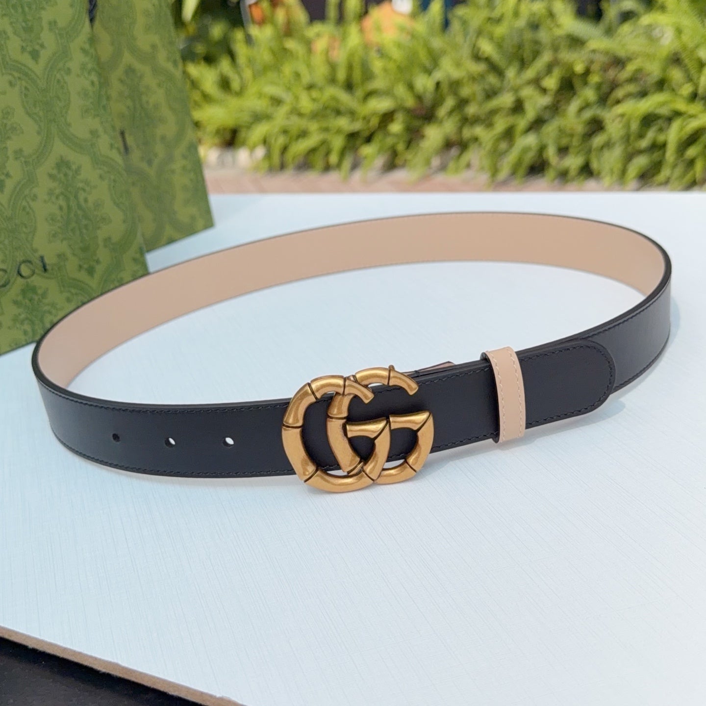 Gucci belt in dark leather with gold-tone double-G buckle and tan keeper strap