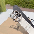 Cream-and-dark leather belt with silver-tone double G buckle, close-up end