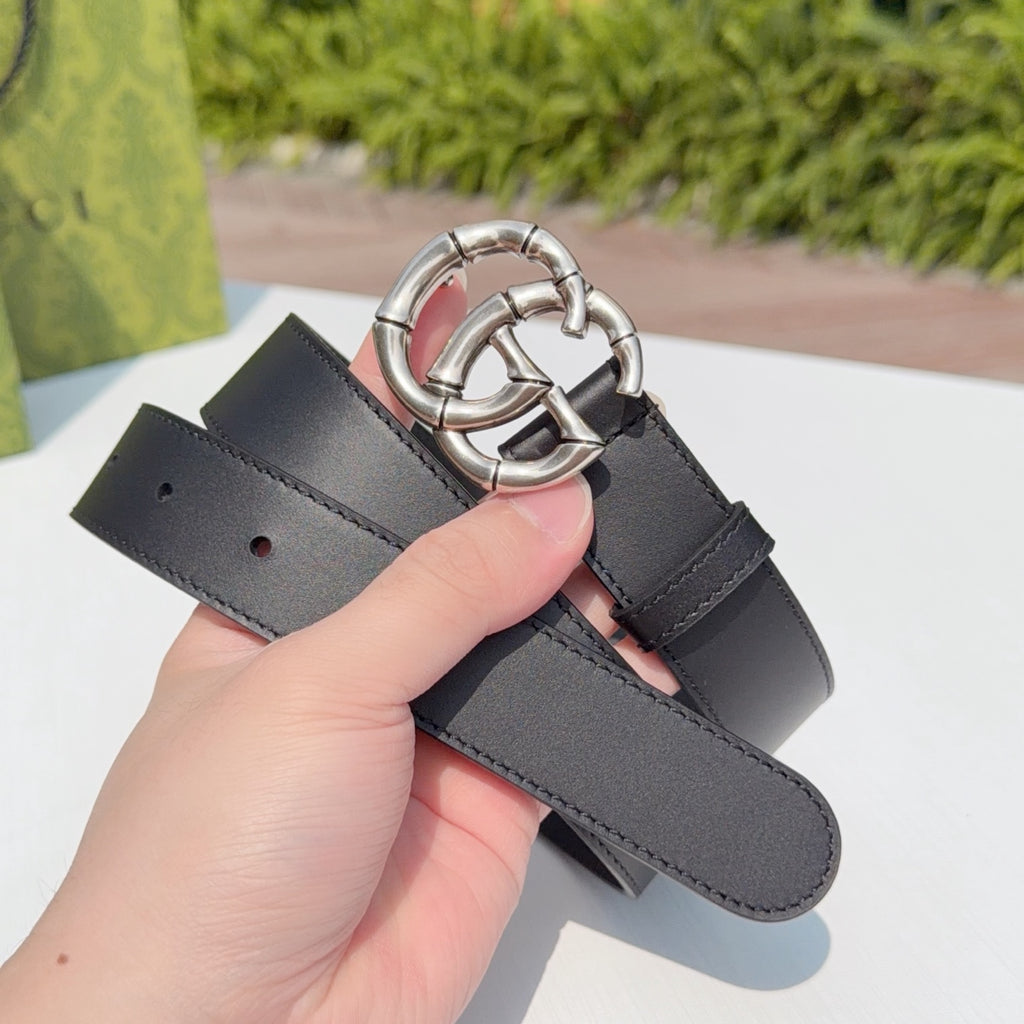 Gucci belt held up, dark leather strap with silver double-G buckle detail