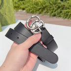 Gucci belt held up, dark leather strap with silver double-G buckle detail