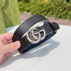 Leather belt close-up with silver double-G buckle and dark strap