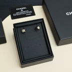 Chanel stud earrings with faux pearl domes and gold-tone CC logo on black enamel
