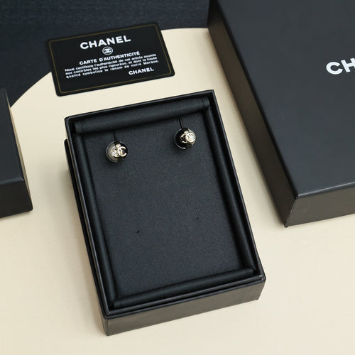 Chanel stud earrings with faux pearl domes and gold-tone CC logo on black enamel