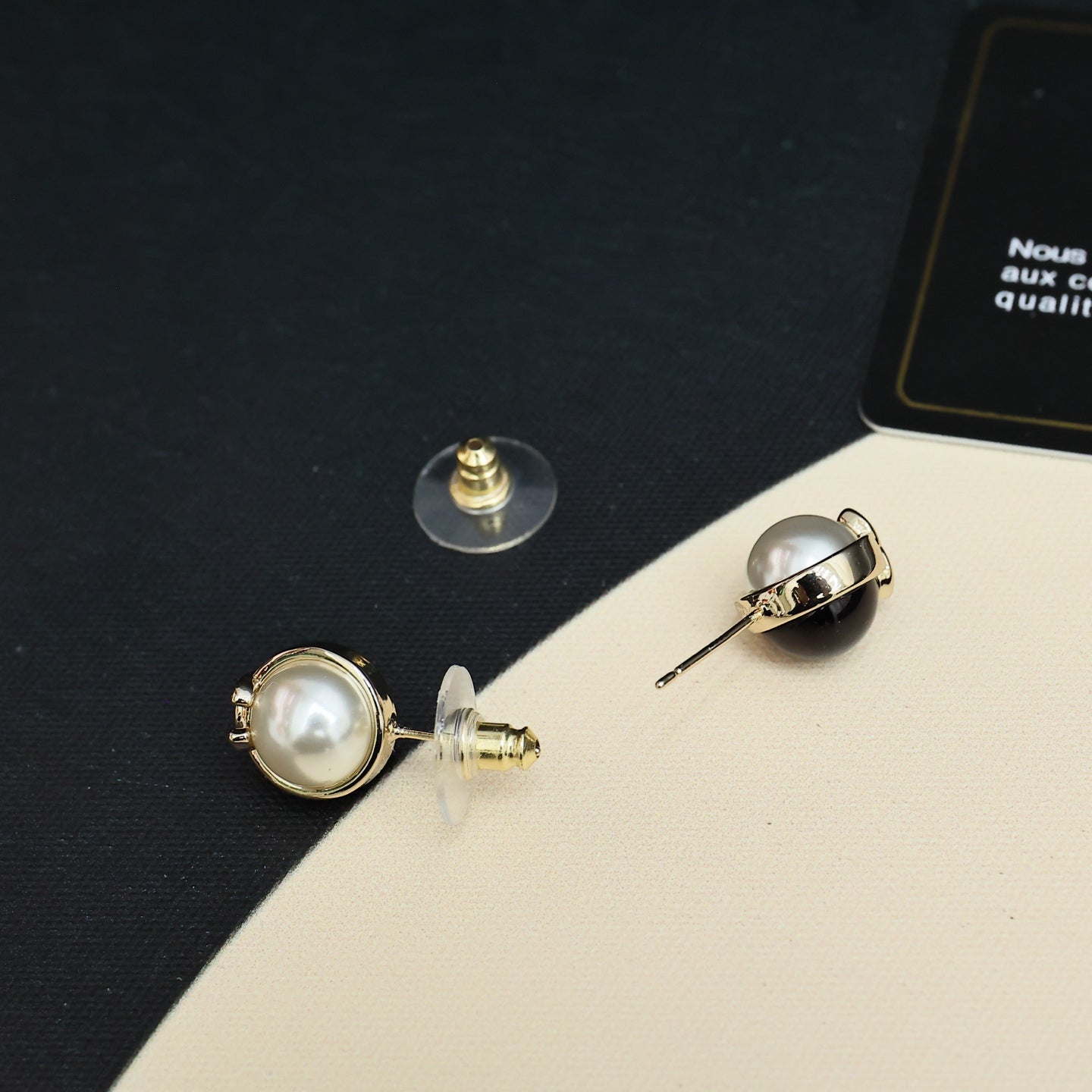 Chanel stud earrings with gold-tone backs, faux pearl fronts, and CC emblem