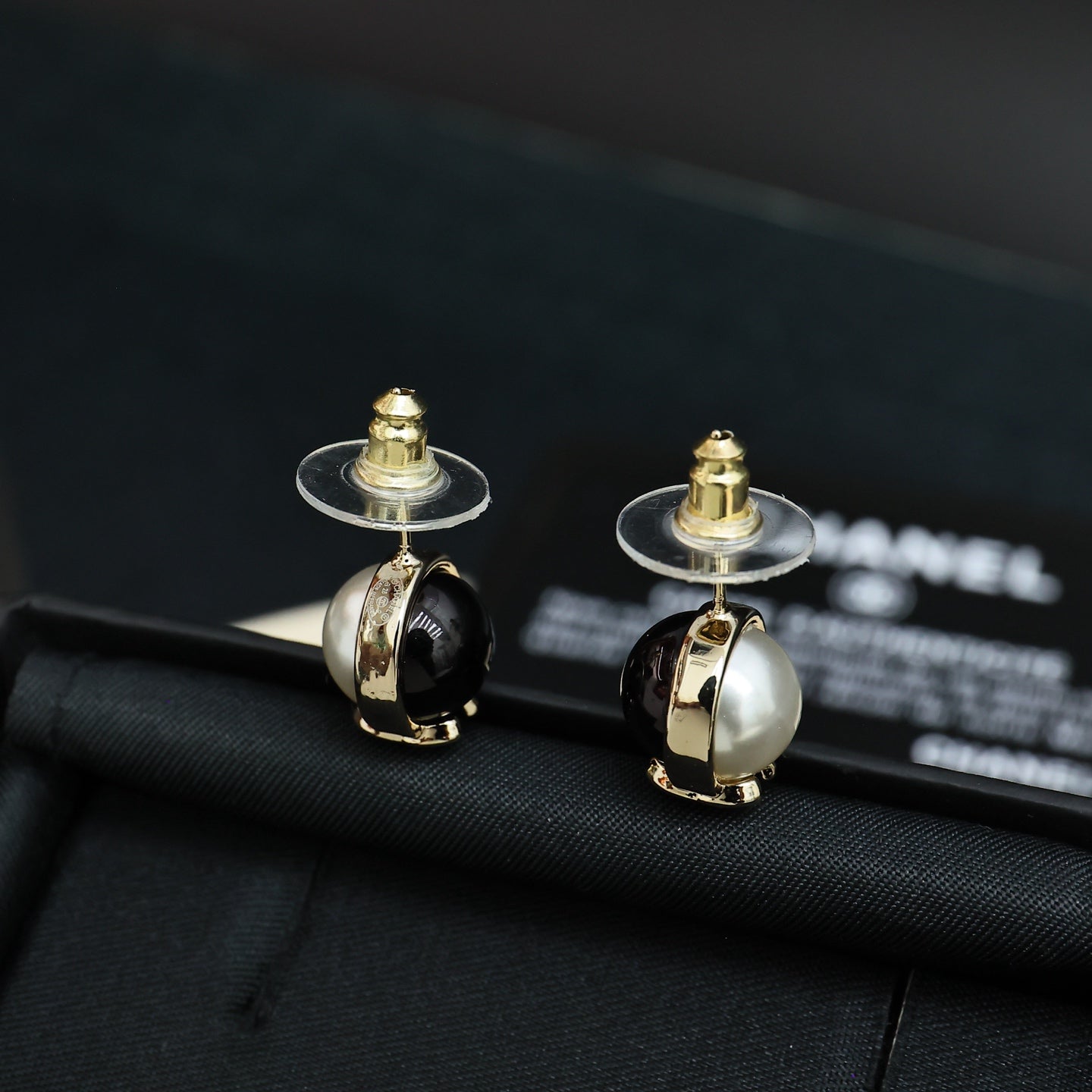 Chanel stud earrings with round faux pearl fronts and gold-tone CC details, black enamel