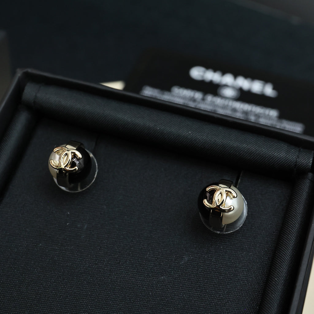 Pair of Chanel stud earrings with gold-tone CC and white faux pearls on black base
