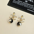 Gold-tone logo earrings with black and pearl drop pendants on card
