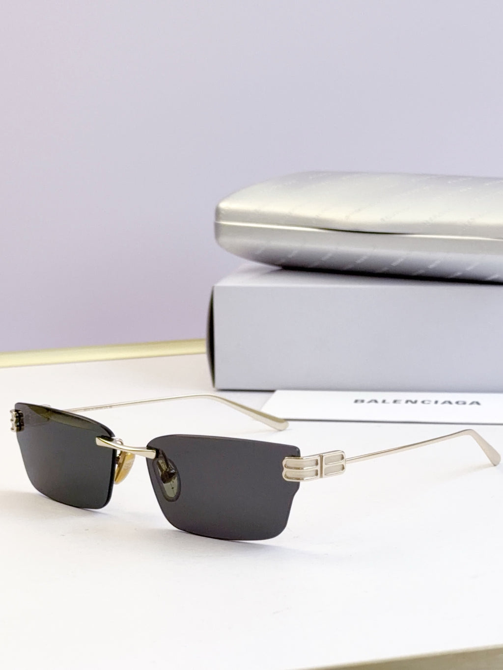Sunglasses with dark lenses and gold-tone rectangular frame