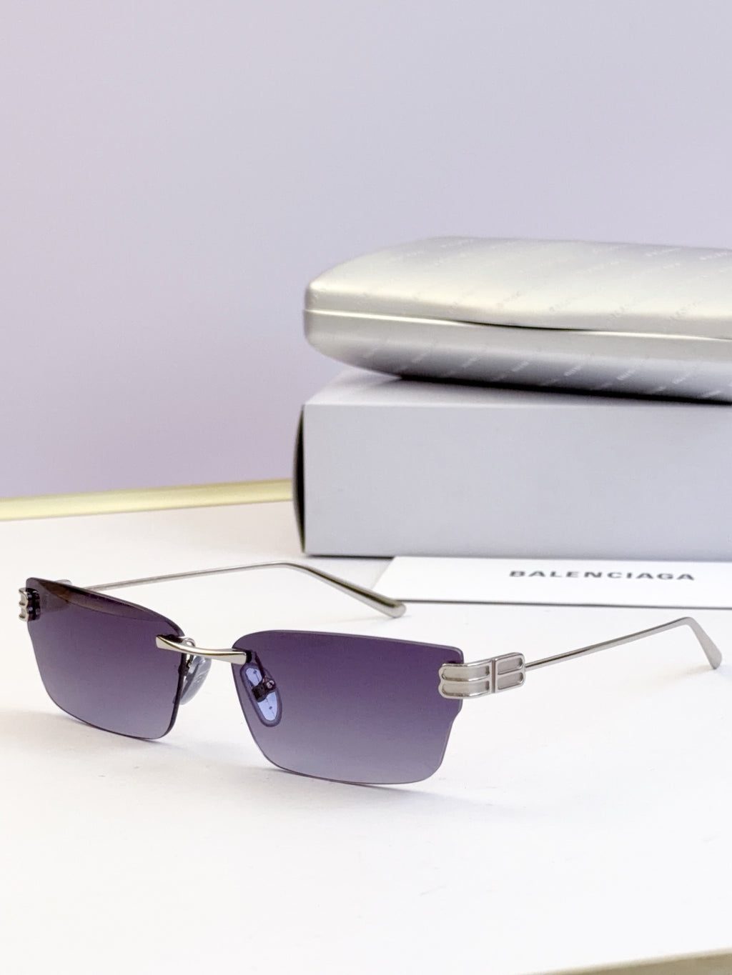 Sunglasses with purple-tinted lenses and gold-tone rectangular frame