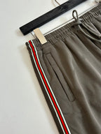 Dark gray shorts close-up: elastic waistband, drawstring, red-green side stripe