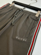 Dark gray Gucci shorts close-up, side stripe trim, stitched pockets, drawstring