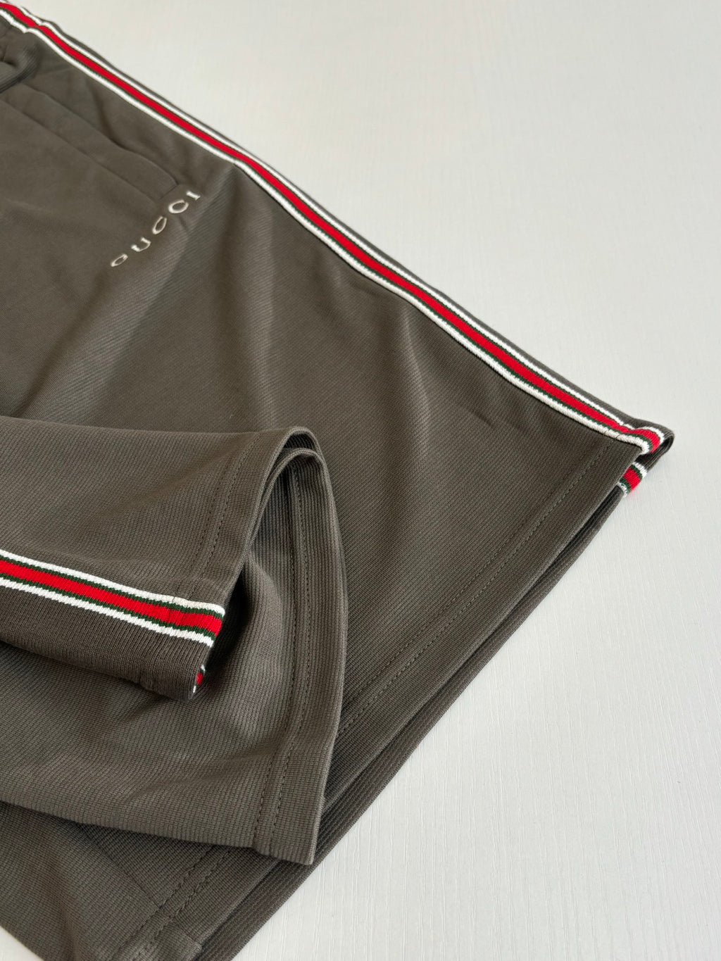 Dark gray Gucci shorts with red-green side stripe and stitched hem