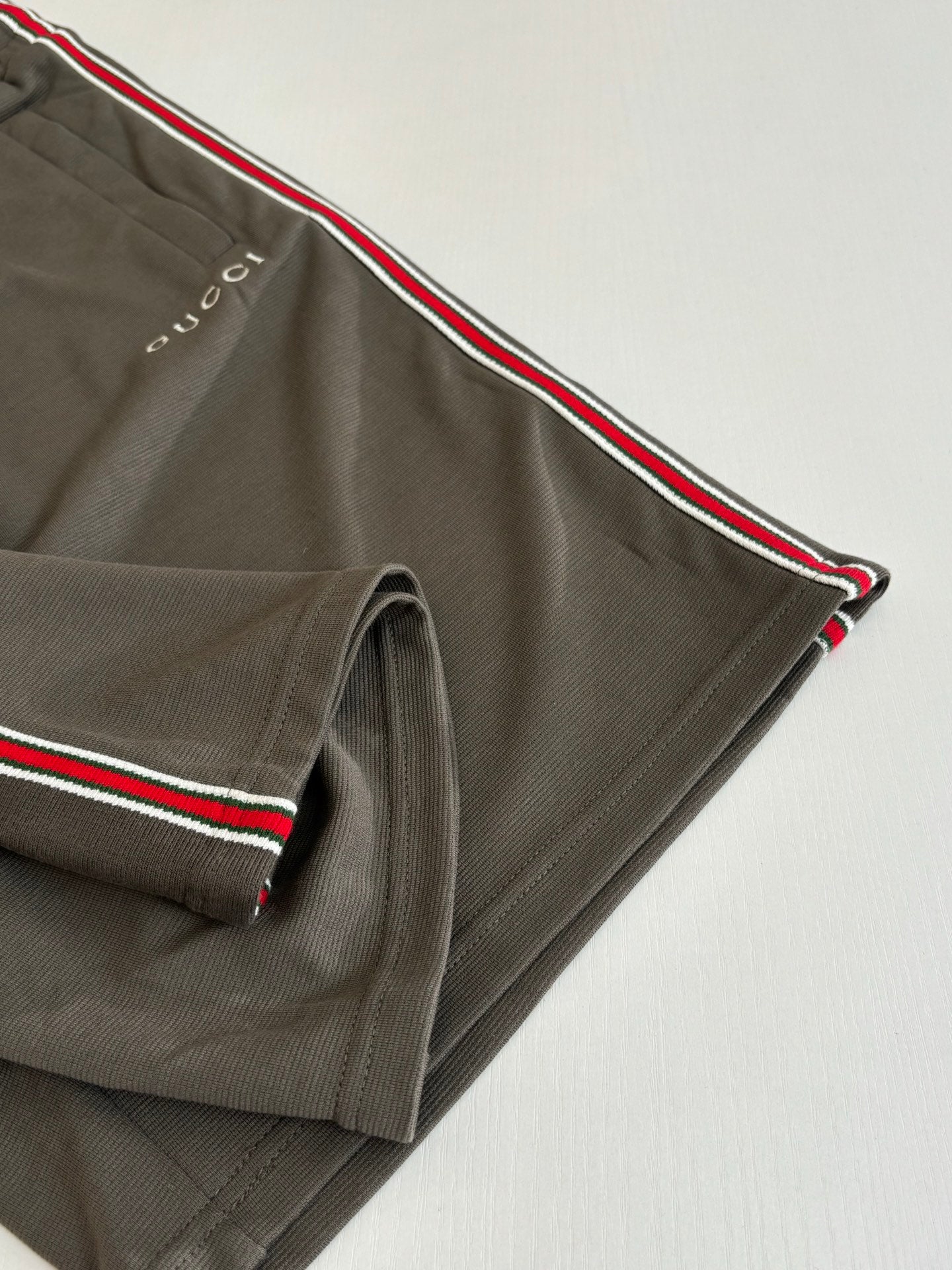 Dark gray Gucci shorts with red-green side stripe and stitched hem